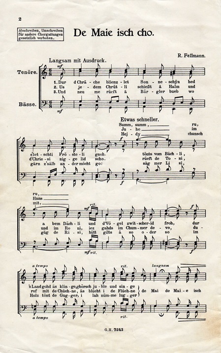 Notenblatt mit dem Titel 'De Maie isch cho' und handschriftlichen Anweisungen zur Aufführung.